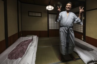 Person in yukata in traditional Japanese room with tatami mats, Takayama, null, Japan
