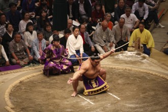 Sumo wrestlers in traditional ceremony in Kokugikan surrounded by spectators, Tokyo, Ryogoku, Japan