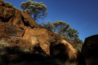 Massive rock formations with sparse vegetation and deep blue sky, Palm Valley, Northern Territory,