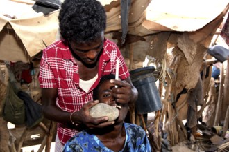 A man performs a dental ritual in the hut, Ahmedela, Tigray, Ethiopia