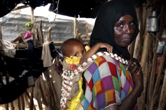 Muhammad's mother and Fatimeh in traditional clothes, the child on the back, Ahmedela, Tigray,