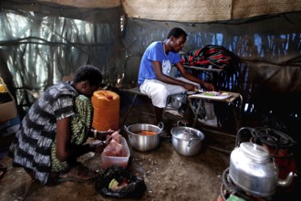 Kusay and Muhammed prepare meals in a camp kitchen in Ahmedela, Ahmedela, Ethiopia