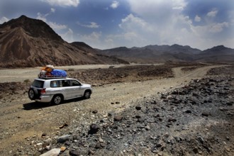 Vehicle drives over rocky road in mountainous desert of Ahmedela, Ahmedela, Ethiopia