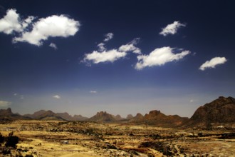 Wide desert landscape with distinctive mountains and isolated clouds in a clear sky, Adua, Tigray,