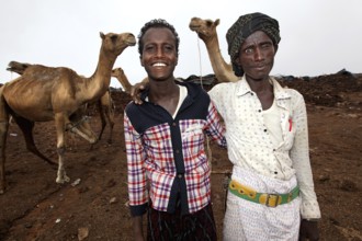 Camel driver with two camels in camp on Erta Ale, smiling at the camera, Erta Ale, Ethiopia