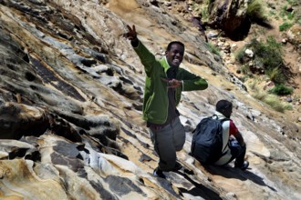 Haile and Kusay carefully climb down the rocky slopes in the Gheralta Mountains, Gheralta