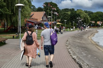 People stroll along the lagoon promenade in Nida on a sunny day, Nida, Curonian Spit, Lithuania