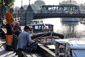 Anglers on the Dange in Klaipeda near a bridge with boats in the water, Klaipeda, null, Lithuania