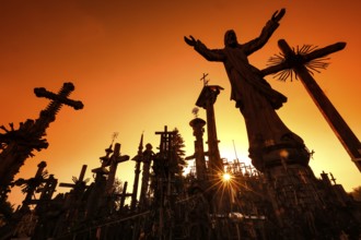 Crosses against light at sunrise on the Hill of Crosses in Siauliai, Siauliai, Lithuania