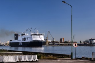 Ferry in the port of Sandkrug in the Curonian Lagoon surrounded by industrial structures, Sandkrug,