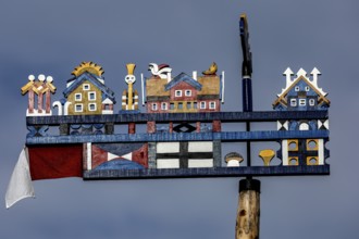 Colourful, traditional Kurenpennant with various symbols against a blue sky, Juodkrante, Klaipeda,