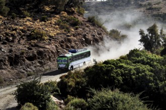 A bus navigates a dusty road in Semien Mountain National Park