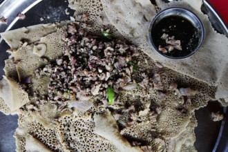 Traditional Ethiopian tibs served on injera in restaurant, Turmi, South Ethiopia, Ethiopia