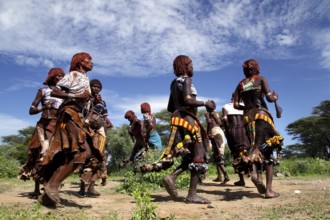 Energetic dance by Hamer woman in traditional surroundings as part of their initiation ceremony,