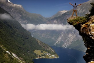 Breathtaking view of the Geirangerfjord from Flydalsjuvet with one person on the edge,