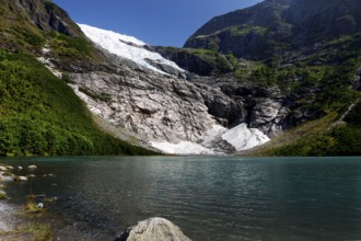 Bøyabreen Glacier Range stretches majestically against a blue sky, surrounded by steep mountains
