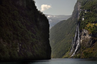 Dramatic waterfall falling in Geirangerfjord surrounded by steep cliffs, Geirangerfjord, Møre og