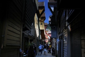 Shady wooden house alley in Tyskebryggen in sunny weather, Bergen, Hordaland, Norway