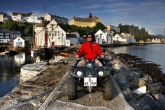ATV rider on the dock in front of the fishing museum in Ålesund in sunny weather, Ålesund, Møre og