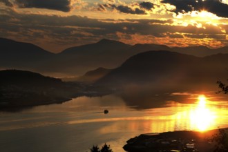 Impressive sunset with reflecting water from Kniven viewpoint in Ålesund, Ålesund, Norway