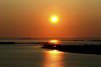 Peaceful sunset scene at Kniven viewpoint in Ålesund with orange sky, Ålesund, Norway