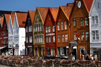 Colourful historic buildings in the Hanseatic Quarter with people passing by, Bergen, Norway