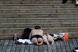 Relaxing bathers on wooden steps in the Bjøvika sun in Oslo, Oslo, Bjøvika, Norway