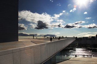 Modern opera architecture in Oslo under bright sun and cloudy sky, Oslo, Bjøvika, Norway