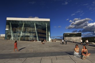 People enjoy sunny day in front of Oslo Opera and Munch Museum, Oslo, Bjøvika, Norway