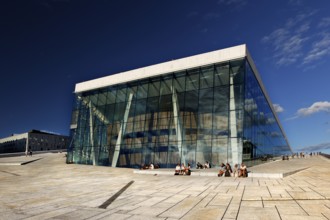 Glass façade of Oslo Opera, an architectural masterpiece in the Bjøvika district under clear skies,