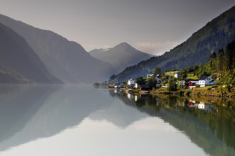 Tranquil fjord landscape with mountains and a small village reflected in the water, Mundal, Norway