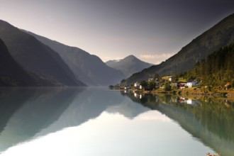Reflection of mountains in the calm water of Fjærlandsfjord near Mundal, Mundal, Norway