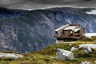 Panoramarestaurant Øygardstølen towers dramatically over the Lysefjord under a grey sky, Lysefjord,