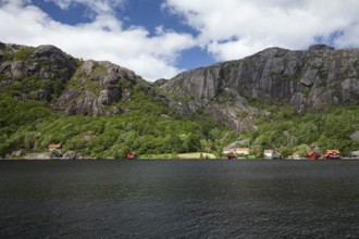 Red cabins by a lake with granite mountains in the background. Summer, Highland (Terra alta),