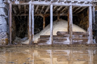 Salt piles stored inside traditional wooden structures at the anana salt valley, showcasing the
