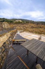Terraced salt pans of the historic anana salt valley in alava, basque country, reflecting a cloudy