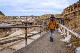 Woman exploring the ancient salt flats of anana, finding herself immersed in the historical