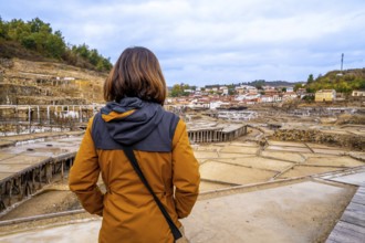 Woman tourist standing at anana salt valley, observing terraced evaporation ponds and traditional