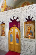 Artfully decorated church door with icons and detailed reliefs in a sacred space, domed church by