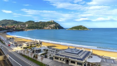 La concha bay beach with golden sand, santa clara island and mount igueldo rising above san