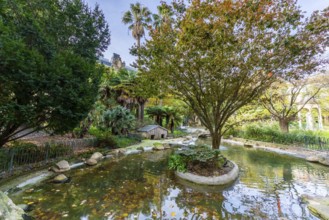Gipuzkoa square showcasing a tranquil pond and green trees with hints of autumn foliage, reflecting
