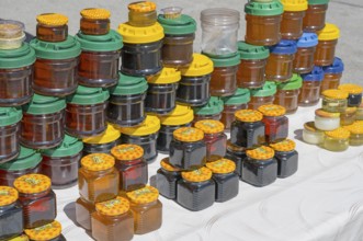 Lots of colorful honey jars with various lids on a market stand, near Gudauri, Mtskheta-Mtianeti