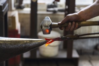 A blacksmith forging, working at the Ehnert forge in Dresden-Bühlau, Saxony, Germany
