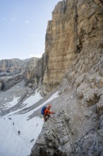 Mountaineer climbs on an exposed rock in the secured Via Ferrata Bocciere Centrale via ferrata,