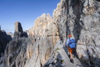 Two mountaineers on an exposed rock band in the secured Via Ferrata Bocciere Centrale via ferrata,