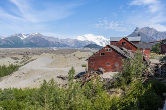 Red Kennicott buildings in front of mountainous landscape, Kennicott Concentration Mill to extract