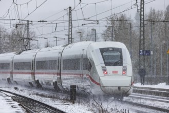 ICE traveling through a winter landscape in snowfall. A train on the line in the Deutsche Bahn