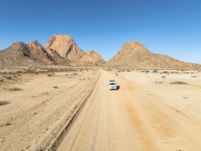 Aerial view, car on sandy road, mountains in the desert, Spitzkoppe summit, Namib desert, Namibia