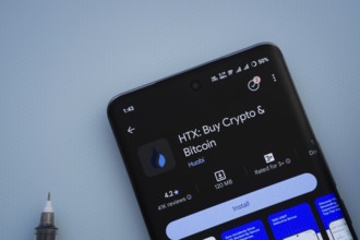 Dhaka, Bangladesh- 29 May 2025: On a blue surface, a smartphone displays the HTX app within the