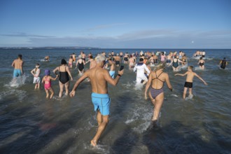 Swimmers run into water to bathe, tourist attraction Binzer Abbaden, Binz, seaside resort, Rügen